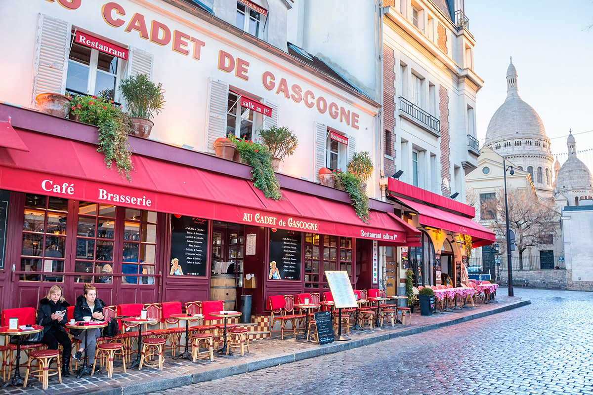 cafe in montmartre with sacre coeur in background